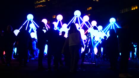 Crowd-interact-with-illuminated-Affinity-neuron-artwork,-Chavasse-park,-Liverpool-River-of-light