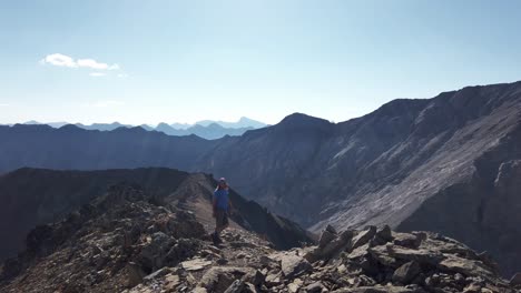 Hiker-on-ridge-over-mountain-range-waiting-approached-Kananaskis-Alberta-Canada