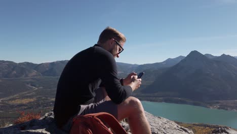 Hiker-on-top-of-Mountain-texting-Kananaskis-Alberta-Canada