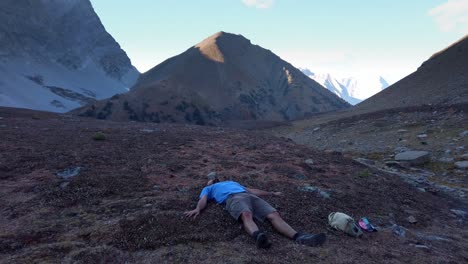 Hiker-laying-down-doing-angels-caressing-in-mountains-pull-away-Kananaskis-Alberta-Canada