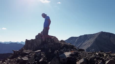 Hiker-on-peak-finding-and-retrieving-time-capsule-approached-Kananaskis-Alberta-Canada