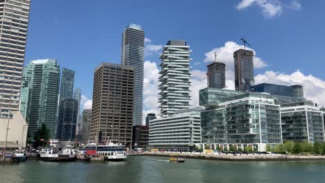 Toronto-ferry-terminal-with-Toronto-Star-and-LCBO-buildings-with-boats,-docks-and-water-taxis