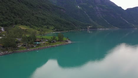 Yrineset-camping-along-turquoise-Oldevatn-glacial-lake-in-Nordfjord-Norway---Aerial-flying-over-lake-and-looking-at-camping-spot