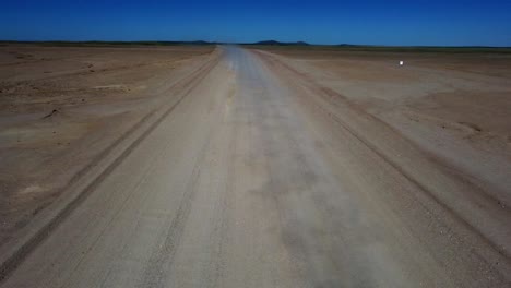 Drohnenaufnahme-Des-Namib-Naukluft-Nationalparks-In-Namibia---Drohne-Fliegt-Auf-Ein-Auto-In-Der-Steppenumgebung-Zu