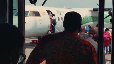 Close-up-African-Passengers-Queuing-to-Board-an-Air-Cote-d'Ivoire-Bombardier-DHC-8-Q400-Airplane-at-Abidjan-Félix-Houphouët-Boigny-International-Airport