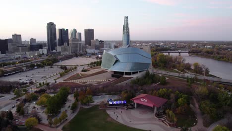 Aerial-view-of-the-Canadian-Museum-for-Human-Rights-and-the-Winnipeg-sign,-in-Manitoba,-Canada---pull-back,-drone-shot