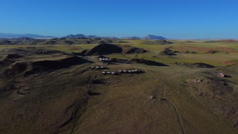 Drohnenaufnahme-Des-Namib-Naukluft-Nationalparks---Drohne-Kreist-Um-Ein-Indigenes-Dorf-In-Der-Steppe