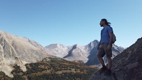 Hiker-looking-at-mountain-range-sighing-circled-Kananaskis-Alberta-Canada