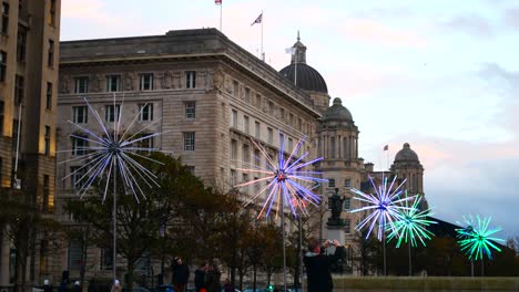 Public-interacting-with-flashing-neon-electric-dandelions-artwork-at-Liverpool-pier-head-river-of-light-event