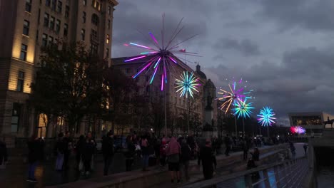 Audience-gathering-around-flashing-neon-electric-dandelions-artwork-at-Liverpool-pier-head-river-of-light-event