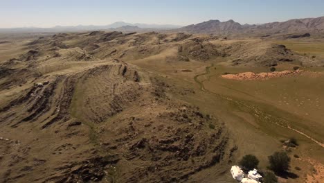 Drone-shot-of-the-Namib-Naukluft-National-Park---drone-is-reversing-over-a-village-in-the-green-steppe-of-Namibia