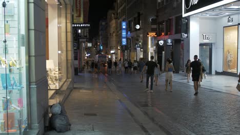 People-walking-through-Ermou-Street-at-night