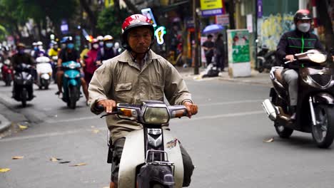 Alter-Mann,-Der-Auf-Dem-Motorrad-In-Der-Hanoi-Straße-Vorbeifährt