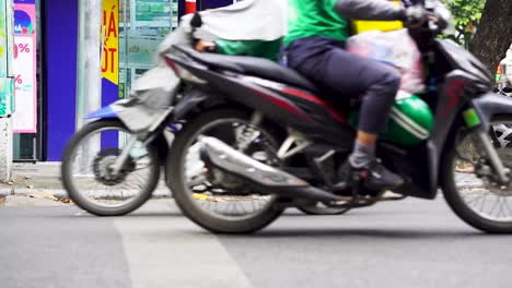 Rack-Fokusaufnahme-Von-Motorrädern,-Die-Durch-Das-Geschäftige-Geschäftsviertel-Von-Hanoi-Fahren