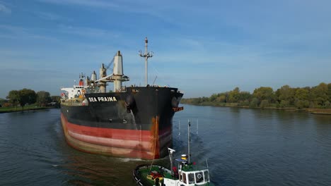 Aerial-Parallax-Around-Tug-Boat-Assisting-Sea-Prajna-Bulk-Carrier-As-It-Navigates-Along-Oude-Maas