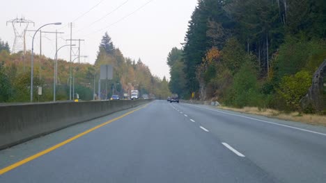 Fahren-Sie-An-Einem-Sonnigen-Herbsttag-Auf-Der-Autobahn-Durch-Waldbäume-Und-Schroffe-Schluchten