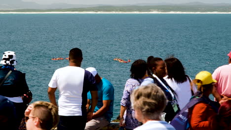 Tourists-at-lookout-point-in-Hermanus-whale-watching,-kayaks-in-background