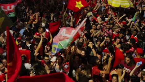 People-take-to-the-streets-in-Porto-Alegre,-Brazil-waving-flags-in-celebration-of-the-election-of-Luiz-Inácio-Lula-da-Silva