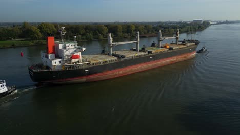Tug-Boat-Attached-To-Stern-of-Sea-Prajna-Bulk-Carrier-As-It-Navigates-Along-Oude-Maas
