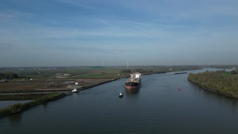 Aerial-View-Of-Tug-Boats-Assisting-Sea-Prajna-Bulk-Carrier-Along-Oude-Maas-As-It-Approaches-Bend