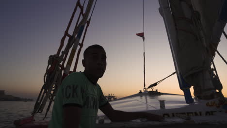Silhouette-Eines-Seemanns,-Der-Den-Sonnenuntergang-Auf-Dem-ägyptischen-Nilo-Fluss-Auf-Einem-Segelboot-Betrachtet
