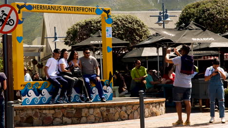 Tourists-making-memories---pictures-taken-in-yellow-Hermanus-Waterfront-frame
