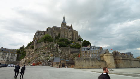 Pullback-On-The-Prominent-Mont-Saint-Michel-Castle-With-Sightseers-In-Normandy,-France