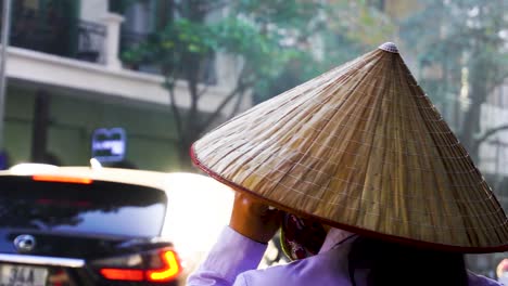 POV-Walking-Around-Traditional-Vietnamese-Woman-Wearing-Straw-Conical-Hat-Talking-On-Mobile-Phone-On-Street-With-Sun-glare