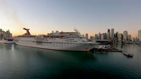 Luxury-Cruise-ship-Carnival-Ecstasy-docked-on-port-in-Miami,-Abstract-video-background-of-Cruise-ship-with-city-skyline-in-background-in-4K