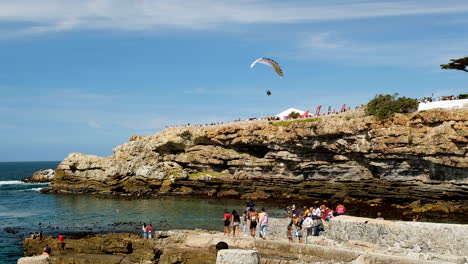 Daring-powered-paraglider-flying-next-to-sea-cliffs-of-Old-Harbour-Hermanus