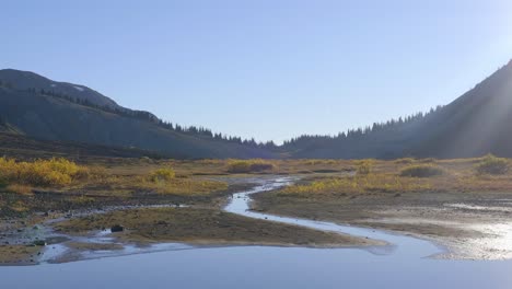 Tranquil-View-Of-Wetland-And-River-With-Mountain-Ranges-In-The-Background