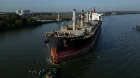 Aerial-View-Off-Forward-Bow-Of-Sea-Prajna-Bulk-Carrier-Being-Assisted-By-Tug-Boat-Along-Oude-Maas