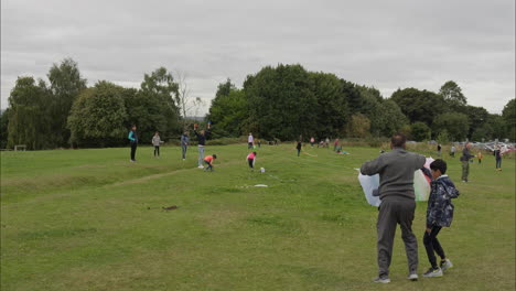 Asian-family-shows-children-how-to-fly-kites-at-a-kite-festival-on-Heath-Common-Wakefield-a-dull-spring-day