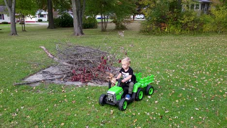 Small-Cute-Kid-Driving-Happily-Green-Tractor-On-Grass-In-House-Yard