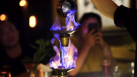 Barkeeper-Gießt-Flammenden-Blauen-Flammencocktail-Auf-Abgestufte-Tassen-In-Hanoi