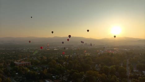 Wide-aerial-shot-of-hot-air-balloons-floating-through-a-hazy-valley-in-America