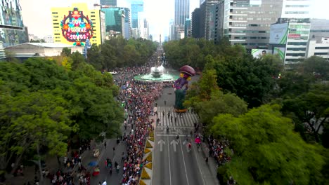 aerial-shot-view-following-a-giant-catrina-inflatable-doll-during-day-of-the-dead-parade-in-avenida-reforma-in-Mexico-city