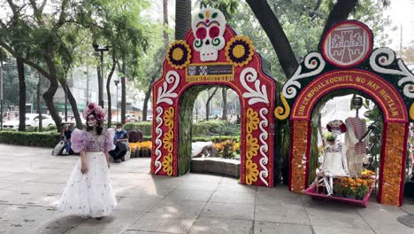 shot-of-catrina-dancing-at-entrance-of-dia-de-muertos-flea-market-in-Mexico-city-at-paseo-de-la-reforma