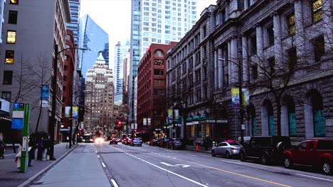 Pan-left-shot-of-west-hastings-street-in-Downtown-Vancouver-with-people-walking-on-the-sidewalks-on-an-overcast-day