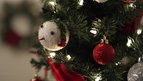 Close-up-isolated-shot-of-hand-decorating-Christmas-tree-with-red-ornament