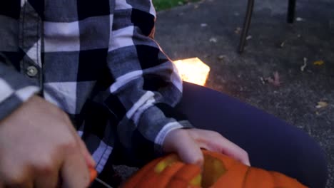 Close-Up-Of-Excited-Blondie-Girl-Carving-Fast-With-knife-Orange-pumpkin,-Halloween