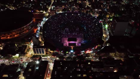 Aerial-view-away-from-the-Ciudad-de-los-deportes-Stadium,-during-Concert-night-in-Mexico-city---reverse,-tilt,-drone-shot