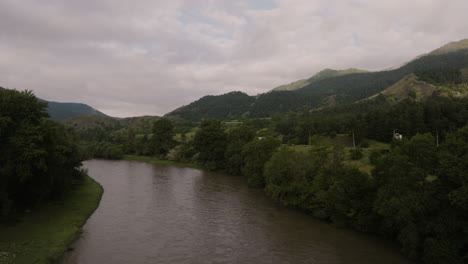 Idyllischer-Fluss-Mit-üppigen-Gehölzen-Und-Kaukasus-Gebirge-Im-Hintergrund-In-Georgien