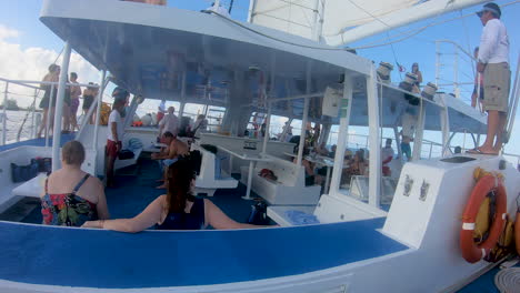 Cozumel,-mexico,-12-11-2022,-people-enjoy-catamaran-ride-during-sunset-in-Caribbean-sea-in-Mexico,-a-group-of-people-travelling-in-catamaran-sail-boat-video-in-4k