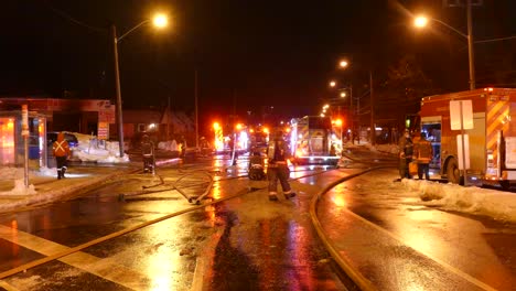 Firefighters-trucks-at-road-intersection-pratice-in-real-life-drill-during-nighttime,-Emergency-lights-on,-Canada