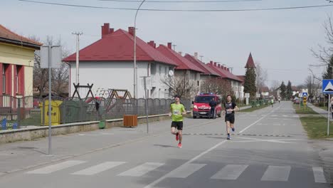 Slo-Mo-Panning-Shot-Of-Two-Man-Running-and-Competing-At-Marathon,-Croatia,-Durdenovac,-2022