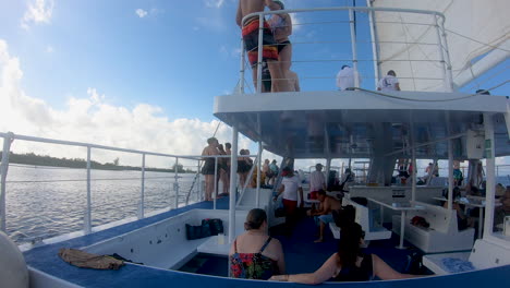 Cozumel,-Mexiko,-12-11-2022,-Die-Leute-Genießen-Eine-Katamaranfahrt-Während-Des-Sonnenuntergangs-Im-Karibischen-Meer-In-Mexiko,-Eine-Gruppe-Von-Menschen,-Die-In-Einem-Katamaran-segelboot-video-In-4k-Reisen