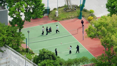 A-number-of-high-school-students-playing-volleyball-on-the-field