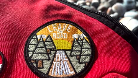 Leave-the-road-Take-the-trail-patch-on-a-backpack