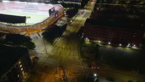 Aerial-view-over-a-tram-on-the-Texas-avenue,-night-in-Houston-city,-USA
